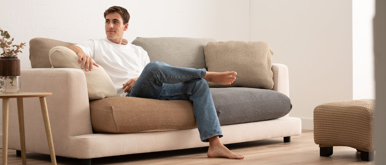 Sofá con funda de cojines de asiento y respaldo, persona sentada
